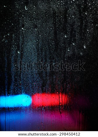 Window and water drops, emergency lights on background, rainy and dark theme