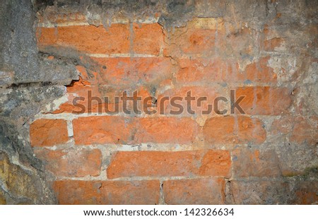 Background texture of an old wall with red bricks showing under the falling concrete