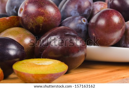 Full frame image of a large group of fresh plums on wooden table