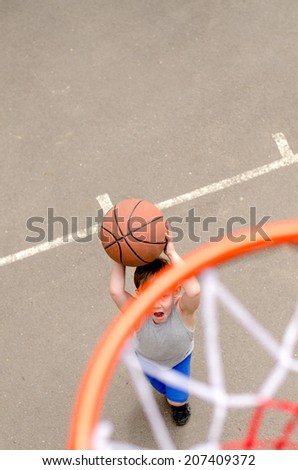 Young boy playing basketball in an outdoor court top view