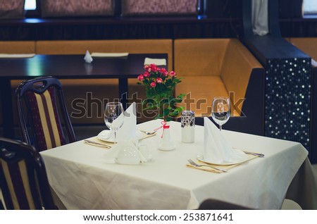 Elegant Table Setting, with Fresh Flowers on Vase at the Center, in Expensive Restaurant