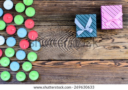 Two Gift box with candles on wooden background