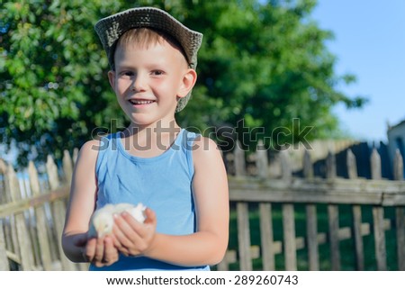 Cute White Young Boy Holding His Little Chick While at the Grassy Garden and Ready to Play.