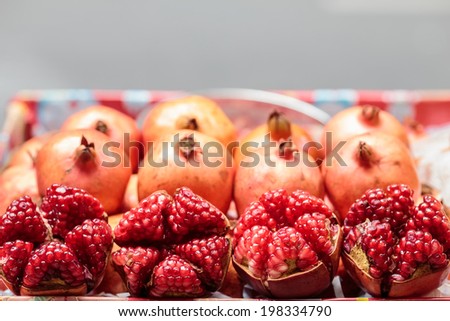 ,red Pomegranates on ice box sale at market ,box blur on gray road background