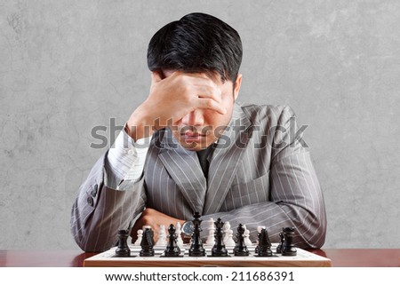 businessman thinking playing chess in strategy and plan concept against concrete wall