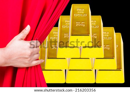 woman hand pulling red velvet luxury curtain place for stack gold bars