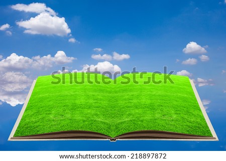 green grass on open recycled book over blue sky in ecology concept