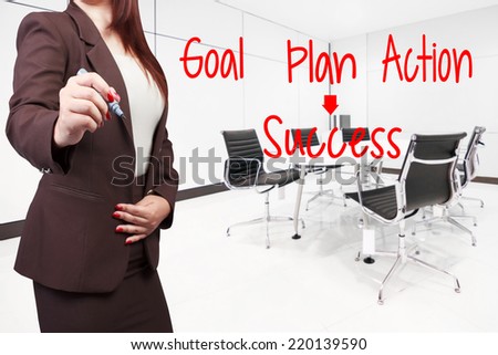 business woman writing word goal plan action success on virtual screen at conference room in modern office interior