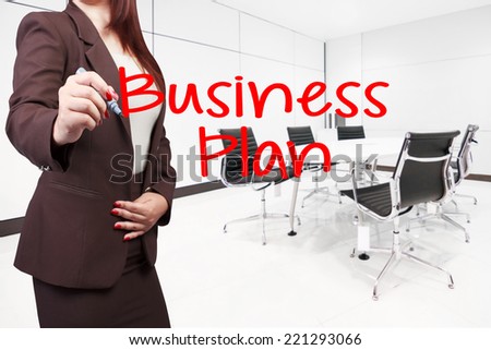 business woman writing word business plan on virtual screen at conference room in modern office interior