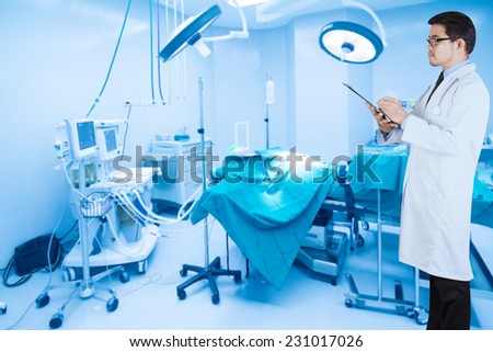 rear view image of doctors with stethoscope pose arms crossed behind back looking at operating room of a modern hospital