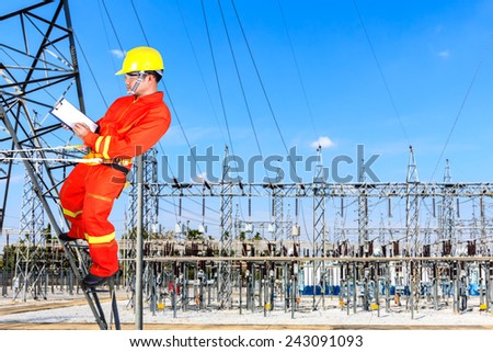 technician wearing puts on a safety climbing harness dressed in other safety gear for working on the heights at power plant