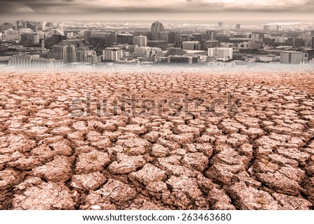 Drought land and cracked earth against city dusky before rain falling with climate change and global warming