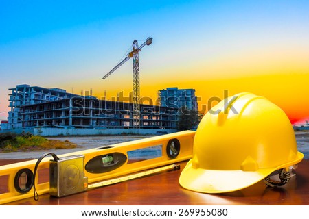 engineer working table plan at building construction site against beautiful sky sunset
