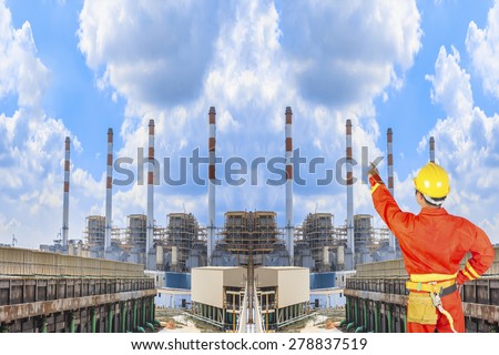 Engineer pointing at Industrial power plant with cloud sky