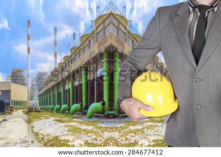 Engineer holding hard hat working at cooling tower of Industrial power plant