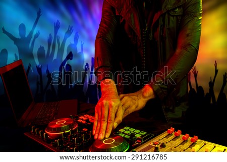 Disc jockey mixer turntable with crowd dance in nightclub at party