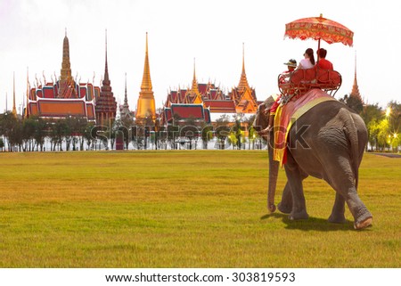 Elephant and tourists on an ride tour of the grand architecture, a venue now mostly used for ceremonial events. The Buddhist temple of Wat Phra Kaeo at the Grand Palace in Bangkok, Thailand