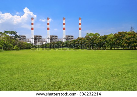 Modern thermal power plants and electric high voltage towers with green park ecology