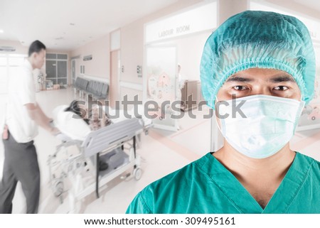 Surgeon looking at camera and medical active staff pushing stretcher gurney bed in labour room of hospital corridor with female patient pregnant in emergency status