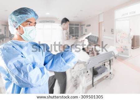 Surgeon pointing at labour room of hospital and medical active staff pushing stretcher gurney bed in  with female patient pregnant in emergency status