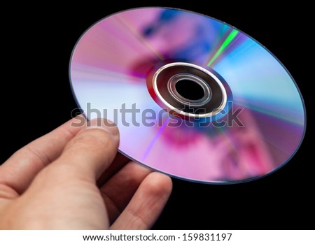 Hand holding DVD Over Black Background.