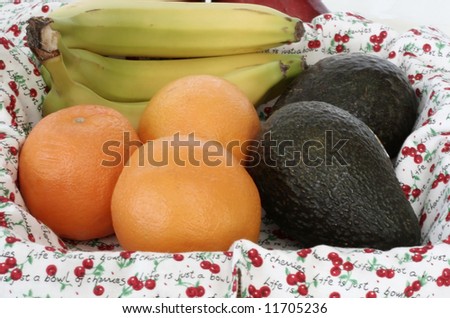 Bananas,oranges and avocado in a lined basket