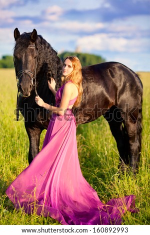 Beautiful woman with a horse and long pink dress