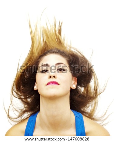 Portrait of a young  woman with blue shirt and her hair in the wind over white background