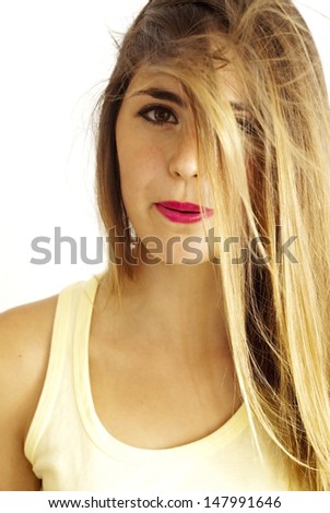 Portrait of a young  woman with yellow shirt and hair in the face over white background
