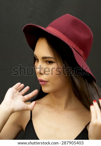 Portrait of Beautiful Young Woman With Red  Hat Over Black Background