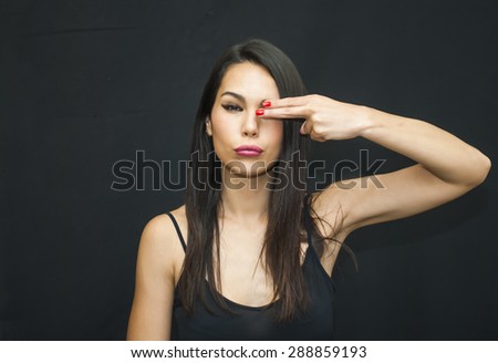 Portrait of Beautiful Young Woman covering one eye with her hand Over Black Background