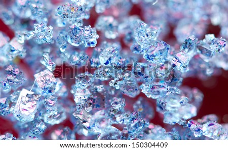 Blue crystals on a red background. Extreme closeup. Macro