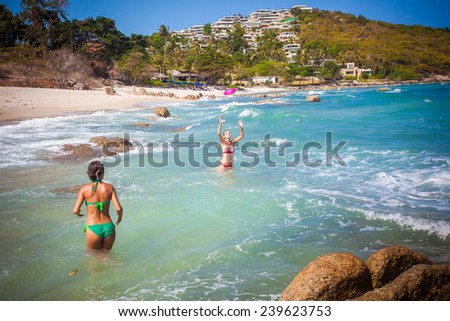 beautiful young woman wearing a green bikini playing  at the beach with her friend on Koh Samui. Thailand