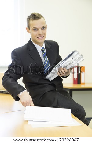 attractive young man in the office with folders