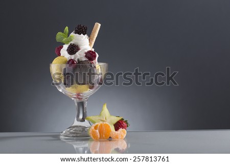 red berries sundae decorated with star fruit, mandarin, and mint