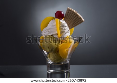 peach melba decorated with whipping cream, and peach