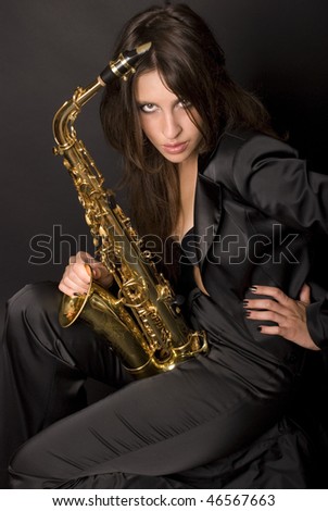 beautiful brunette long haired girl wearing black suit and black nails with her jazz saxophone