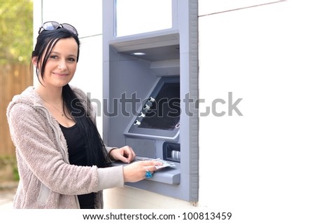 Woman withdrawing money from credit card at ATM
