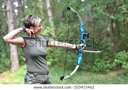 young woman with a bow and arrows in the woods