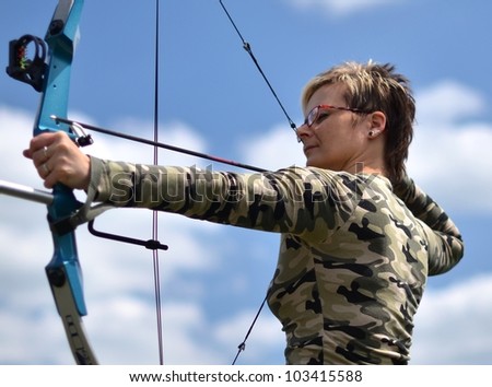 young woman with a bow and arrows on blue sky background