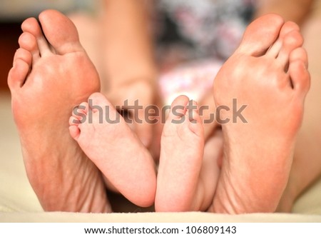 mother and baby\'s foot together