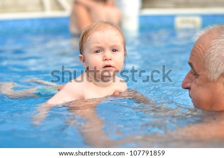 baby with grandfather in pool
