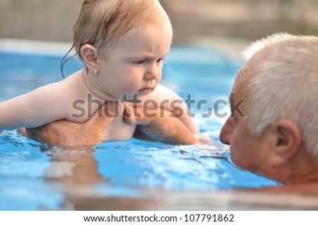 baby with grandfather in pool