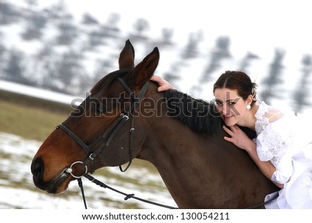 Young happy smiling woman with horse. Winter sport