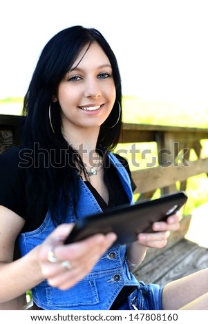 Attractive student in nature holding digital tablet