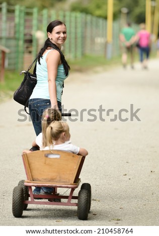 Two happy girls in a wooden wagon