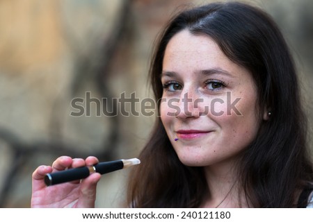 Young woman smoking electronic cigarette (e-cigarette)