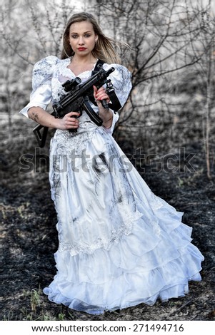 Woman in white dress with gun isolated on white.
