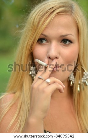 Young teen person smoking cigarette outdoors