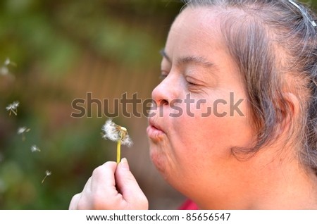 down syndrome woman blowing dandelion